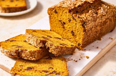 A loaf of The Most Pumpkin Pumpkin Chocolate Chip Bread with a few slices cut out of it - select to zoom