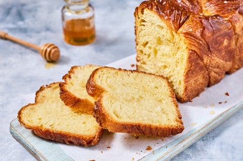 Loaf of Laminated Challah sliced on a cutting board - select to zoom