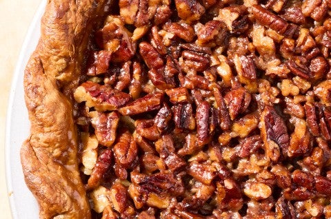 Detail of the surface of pumpkin pecan pie showing carmelized pecans and a flaky crust. - select to zoom