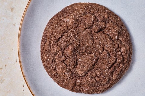 Overhead photograph of a single soft chocolate sugar cookie on a light colored plate. - select to zoom