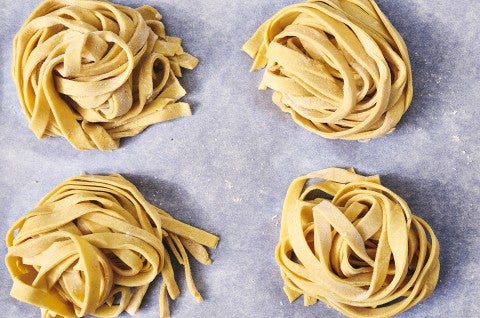 Overhead photograph of raw balls of gluten free pasta on parchment paper. - select to zoom