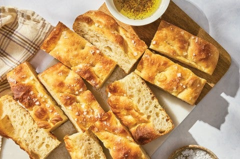 Sourdough Focaccia sliced on a cutting board with a dish of olive oil - select to zoom