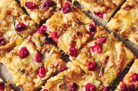 Sliced Caramelized Onion and Brie Pizza showing a golden baked top dotted with pomegranate, brie, and caramelized onion. - select to zoom