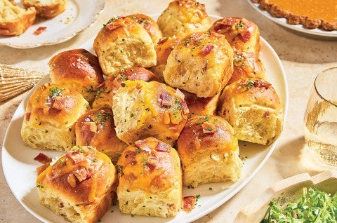 Loaded Baked Potato Dinner Rolls stacked on a plate - select to zoom