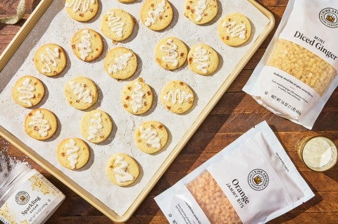 A sheet tray with Glazed Ginger-Citrus Shortbread spread out on parchment paper photographed from above. - select to zoom