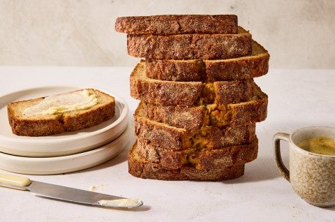 A stack of High-Altitude Banana Bread shown from the side depicting a dark, perfectly baked exterior. - select to zoom