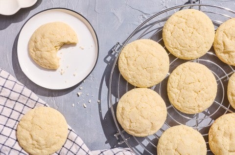 Sourdough Sugar Cookies on a baking rack and another on a white plate photographed from above. - select to zoom