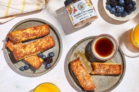 French Toast Sticks on plates with a small dish of maple syrup, King Arthur Baking Maple Cinnamon french toast sugar, and berries. - select to zoom