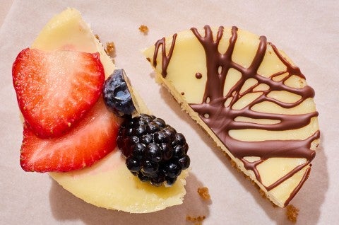 Two Mini Cheesecakes - one with fresh strawberry and blackberry, the other with chocolate - cut in half and placed next to each other. - select to zoom