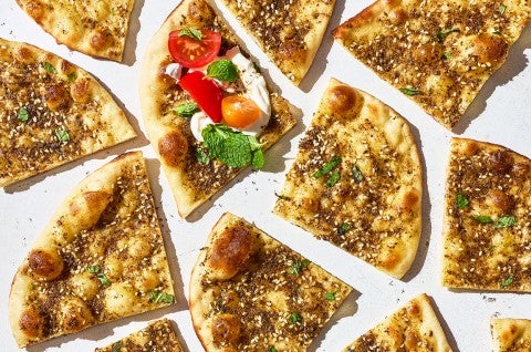 Slices of Za’atar Manakeesh seen from above and arranged randomly on a countertop. - select to zoom
