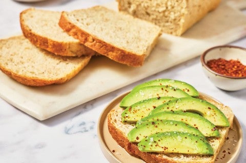 Avocado toast in front of sliced Clay's Multigrain Sourdough bread. - select to zoom