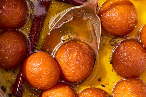 Detailed shot of Gulab Jamun on a spoon. - select to zoom