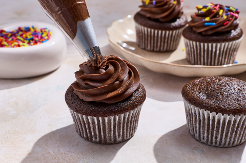 Piping frosting onto a Small-Batch Chocolate Cupcake. - select to zoom