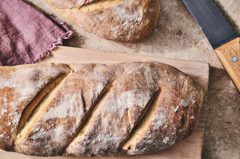 A rustic loaf of bread on a cutting board. - select to zoom