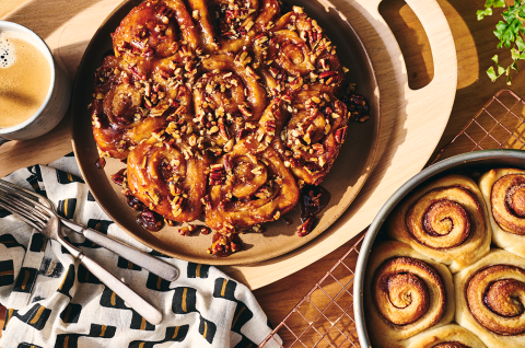 Overhead view of finished sticky buns and their unfinished counterparts. - select to zoom