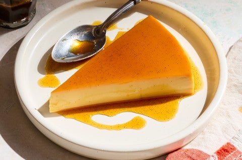 A slice of flan on a white plate. - select to zoom