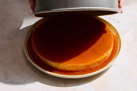 A lid being removed from a flan showing a dramatic shadow and the full desert. - select to zoom