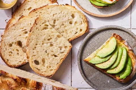 No-Knead Sourdough Bread on a cutting board with some avocado toast - select to zoom