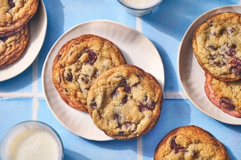 Classic Chocolate Chip Cookies on plates atop a blue counter. - select to zoom