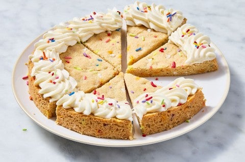 Confetti Sugar Cookie Cake sliced on a plate that's sitting on a marble countertop - select to zoom