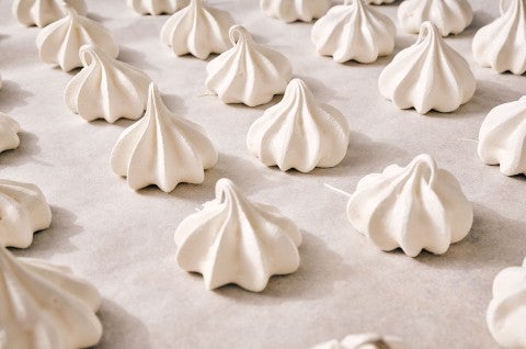 Meringue Kisses in neat rows on a counter. - select to zoom