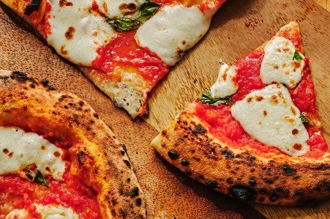 Slices of Margherita Pizza on a wooden counter. - select to zoom