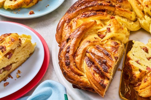 Close up of an Italian Herb & Cheese Wreath sliced and arranged on plates. - select to zoom