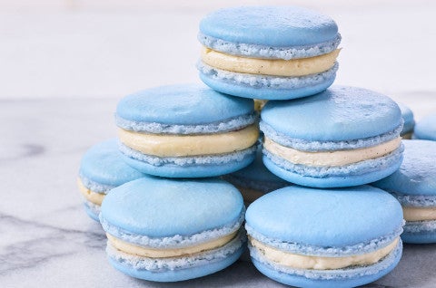 A stack of blueberry macarons on a marble countertop. - select to zoom