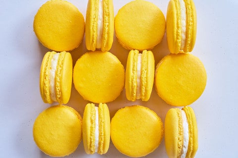 Lemon macarons arranged on a counter and seen from above. - select to zoom