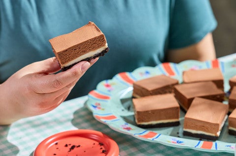 Holding a slice of No-Bake Chocolate Cheesecake Bars - select to zoom