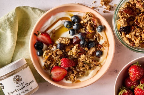 Sourdough Granola atop some yogurt in a bowl along with fresh fruit - select to zoom