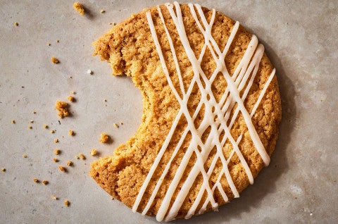A Crispy Brown Butter Cookie with a bite taken out of it and crumbs scattered about - select to zoom