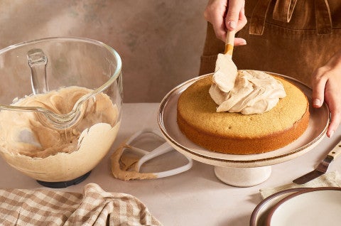 Spreading Brown Butter Cream Cheese Frosting on a caked - select to zoom