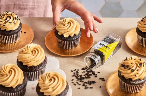 A table with Chocolate Cupcakes with Whipped Caramel Frosting atop it. - select to zoom
