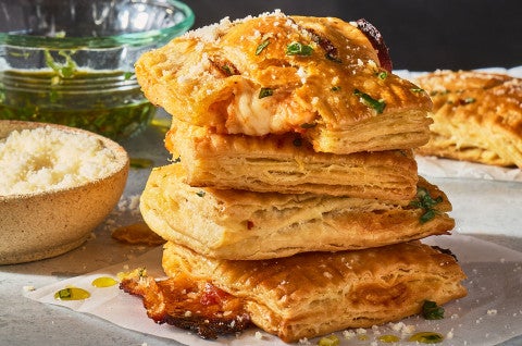 A stack of Flaky Puff Crust Pizza Turnovers seen from the side. - select to zoom