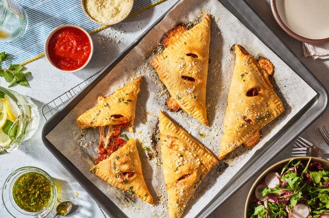 Flaky Puff Crust Pizza Turnovers on a baking sheet - select to zoom