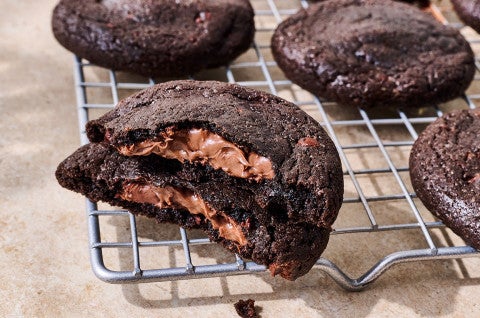 Gluten Free Nutella-Stuffed Cookies on a drying rack showing the nutella center of the cookies - select to zoom
