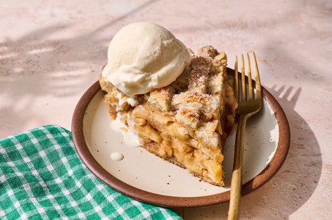 A slice of Gingered Apple Cream Pie on a plate with a scoop of vanilla ice cream on top. - select to zoom