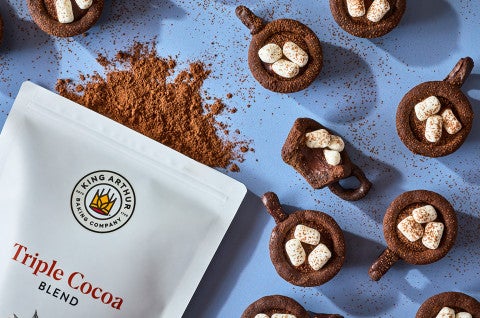 Hot Cocoa Cookie Cups seen from above with a bag of triple cocoa - select to zoom