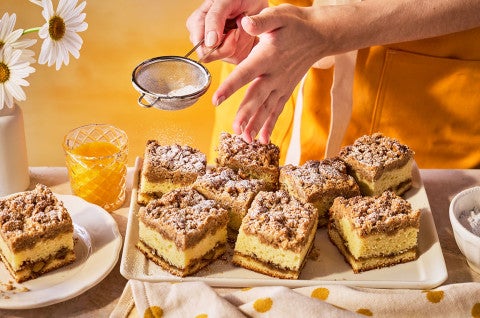 Dusting the tops of Our Favorite Sour Cream Coffee Cake with powdered sugar. - select to zoom