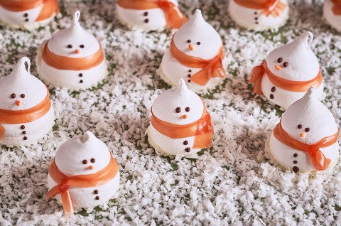 Snowman Meringues arranged on a counter with sugar snow - select to zoom