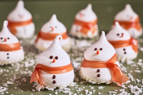 Snowman Meringues arranged on a counter with sugar snow - select to zoom