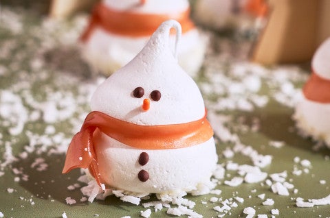 A Snowman Meringue on a green snow-covered surface - select to zoom
