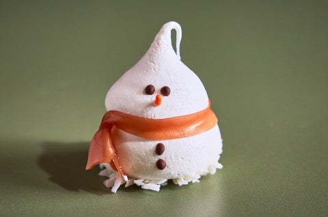 A single Snowman Meringue on a green backdrop - select to zoom