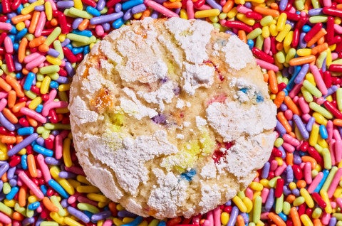 A Sprinkle Crinkle Cookie on a pile of colorful sprinkles - select to zoom
