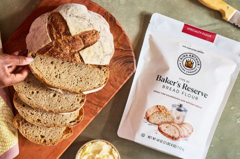 Bag of Baker's Reserve Bread Flour next to a loaf of artisan bread