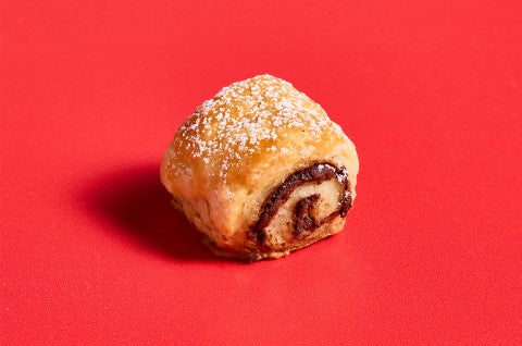 A single Chocolate Croissant Cookie on a red background - select to zoom