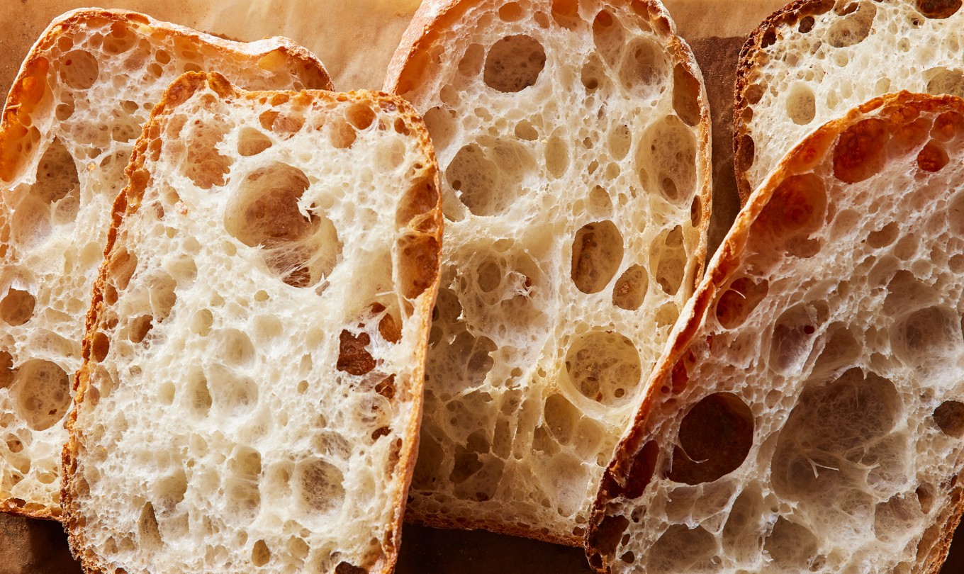 Loaves of Pan de Cristal cut in half showing their very open crumb structure