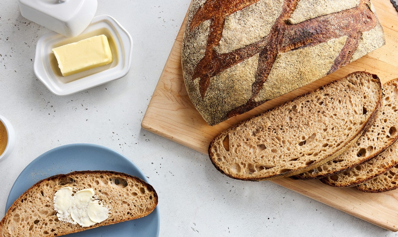 Classic Miche loaf sliced up on a cutting board
