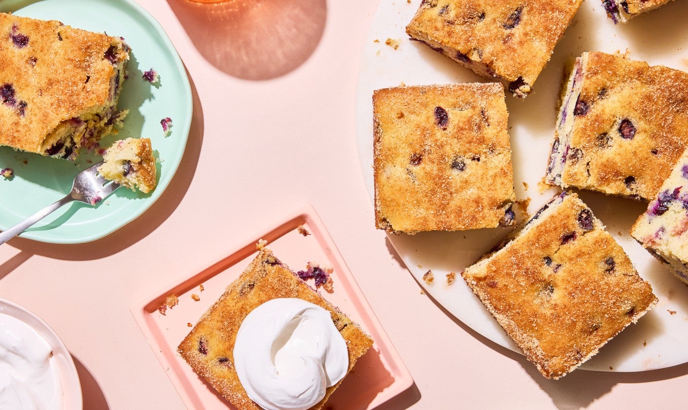 Easy Blueberry Muffin Cake served on a plate with whipped cream